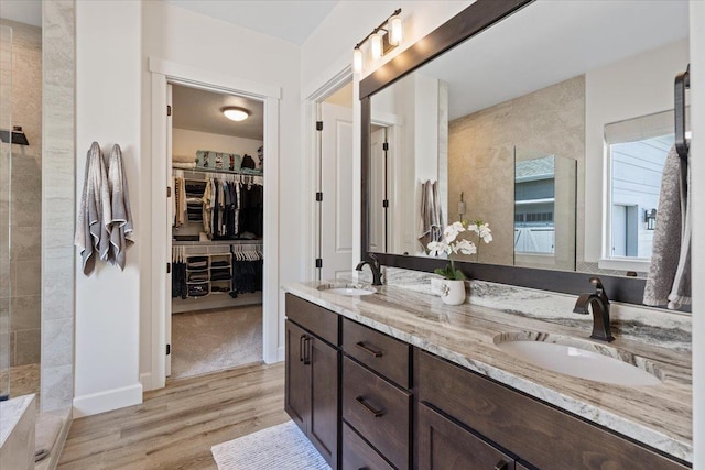 12918 E San Juan Ln, Spokane, WA 99206 - bathroom with double vanity, wood finished floors, a spacious closet, and a tile shower