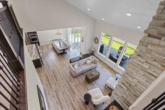 12918 E San Juan Ln, Spokane, WA 99206 - living room with vaulted ceiling, a chandelier, recessed lighting, wood finished floors, and a textured ceiling