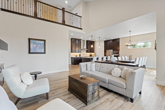 12918 E San Juan Ln, Spokane, WA 99206 - living room with light wood finished floors, a chandelier, and a high ceiling