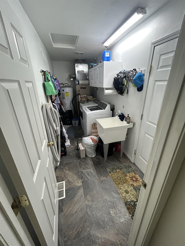 603 W Dennison-Chattaroy Rd, Deer Park, WA 99006 - washroom featuring independent washer and dryer, cabinet space, electric water heater, attic access, and stone finish flooring