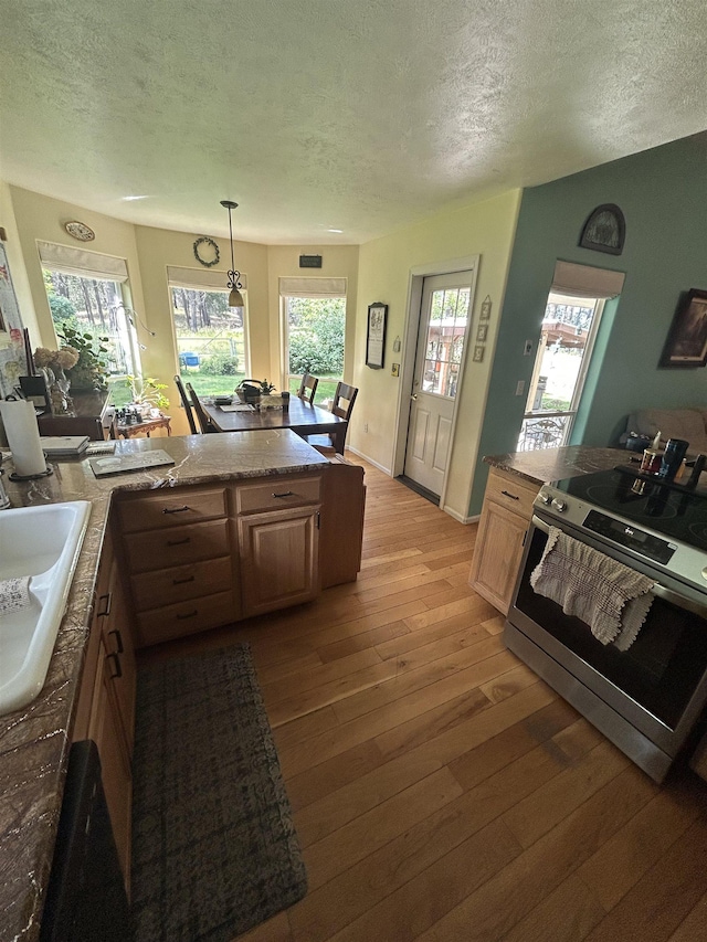 603 W Dennison-Chattaroy Rd, Deer Park, WA 99006 - kitchen featuring stainless steel range with electric cooktop, a textured ceiling, light wood-style flooring, plenty of natural light, and hanging light fixtures