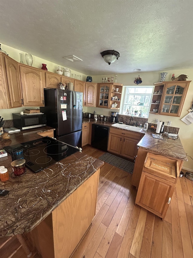 603 W Dennison-Chattaroy Rd, Deer Park, WA 99006 - kitchen with black appliances, light wood finished floors, open shelves, a peninsula, and a textured ceiling