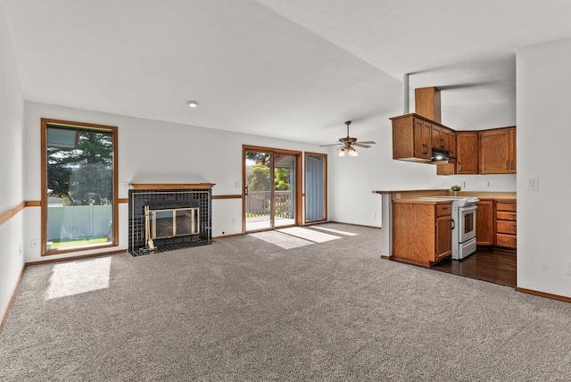 3707 S Alder Ct, Spokane, WA 99223 - unfurnished living room featuring dark colored carpet, a tiled fireplace, and ceiling fan