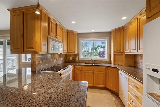 639 N Riverpoint Blvd Unit J201/J202, Spokane, WA 99202 - kitchen with white appliances, recessed lighting, tasteful backsplash, dark stone counters, and brown cabinetry
