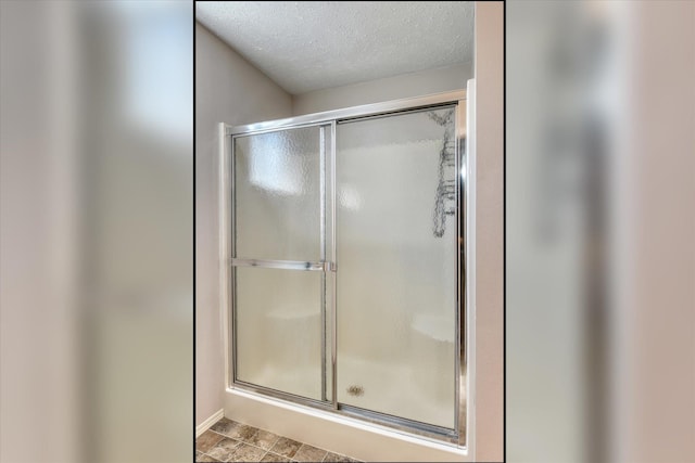 4318 N Upland Ct, Spokane Valley, WA 99216 - bathroom featuring a shower with shower door and a textured ceiling