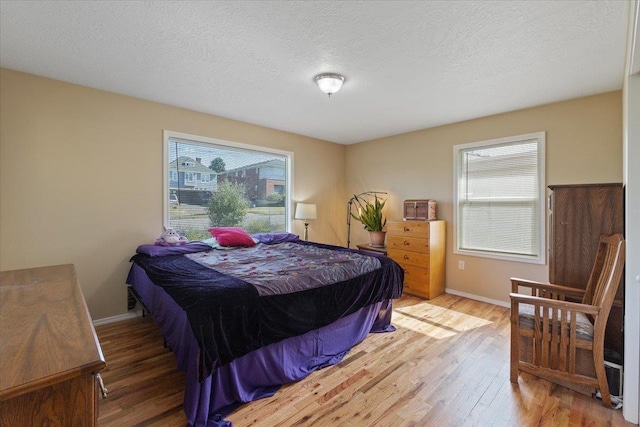 34 E Euclid Ave, Spokane, WA 99207 - bedroom featuring multiple windows, wood finished floors, and a textured ceiling