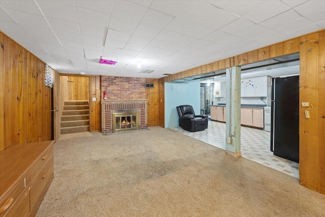 34 E Euclid Ave, Spokane, WA 99207 - unfurnished living room with wood walls, carpet, a fireplace, and stairs