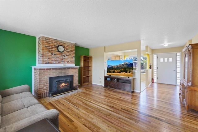34 E Euclid Ave, Spokane, WA 99207 - living room with wood finished floors, a textured ceiling, and a brick fireplace