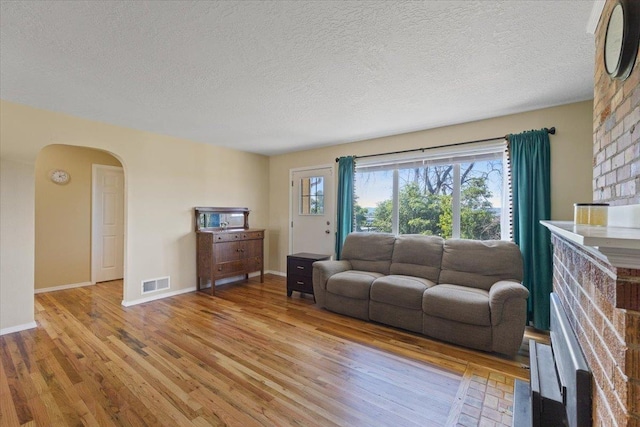 34 E Euclid Ave, Spokane, WA 99207 - living area featuring arched walkways, light wood-style flooring, and a textured ceiling