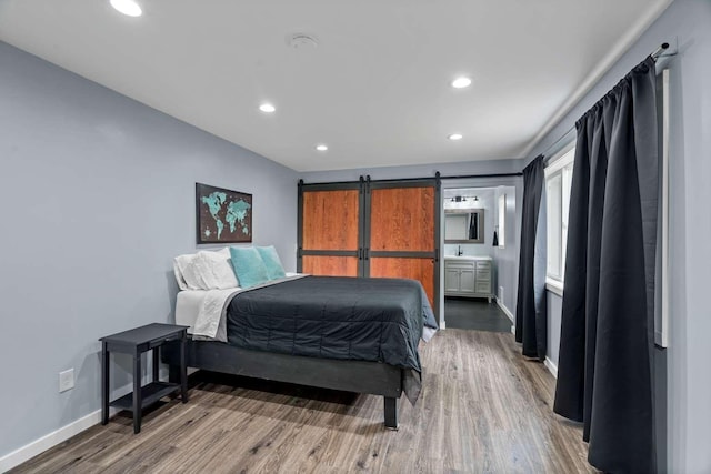 201 Dilling Ln, Cusick, WA 99119 - bedroom featuring wood finished floors, recessed lighting, a barn door, and ensuite bath