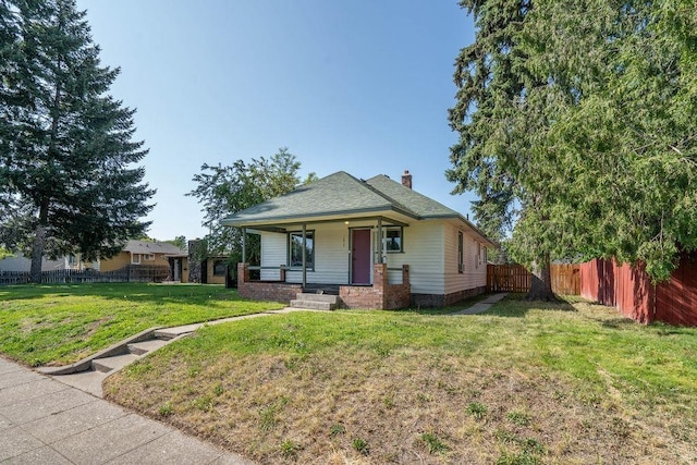 1019 E Everett Ave, Spokane, WA 99207 - bungalow-style home featuring a porch, a fenced backyard, and a chimney