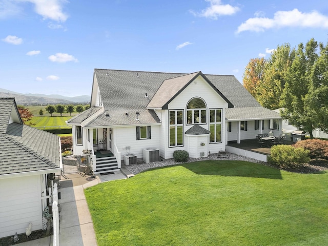 3333 N Ashton Rd, Otis Orchards, WA 99027 - rear view of property featuring a yard, a shingled roof, a mountain view, and a patio area