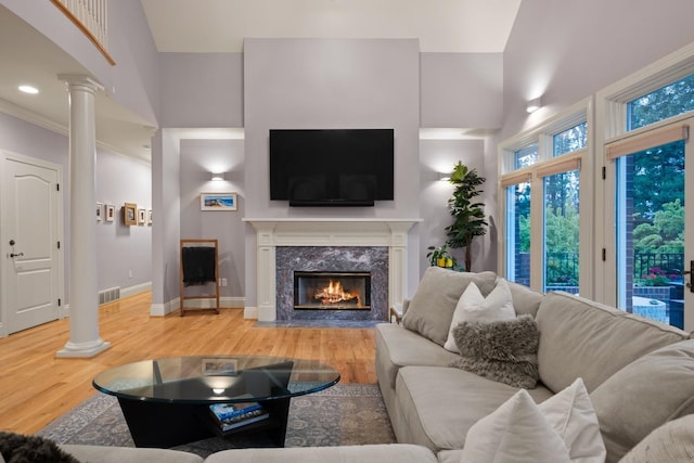 1807 E Pinegate Ln, Spokane, WA 99224 - living area featuring decorative columns, light wood-style flooring, a fireplace, and a high ceiling