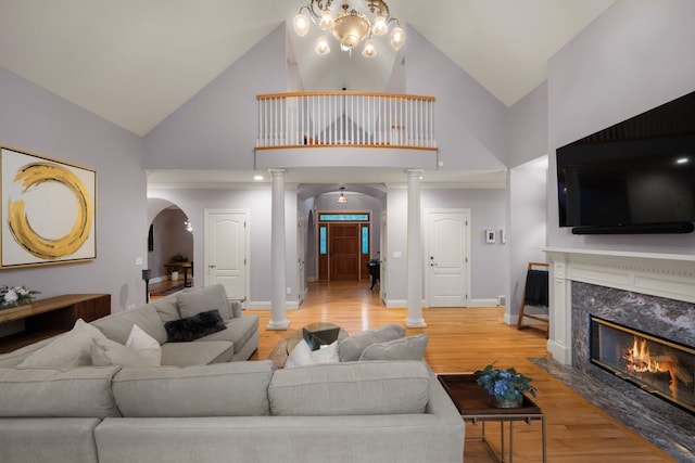 1807 E Pinegate Ln, Spokane, WA 99224 - living area with decorative columns, arched walkways, high vaulted ceiling, light wood-style flooring, and a fireplace