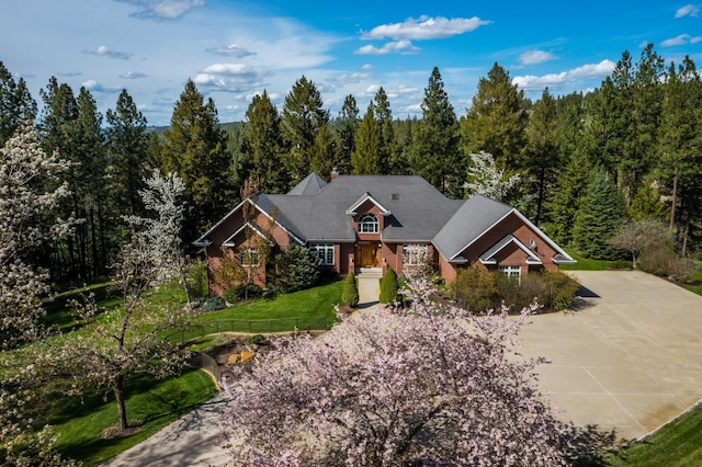 1807 E Pinegate Ln, Spokane, WA 99224 - craftsman house with a forest view, a chimney, and driveway