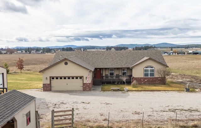 8715 W Antler Rd, Deer Park, WA 99006 - ranch-style home featuring brick siding, a porch, a mountain view, driveway, and a garage