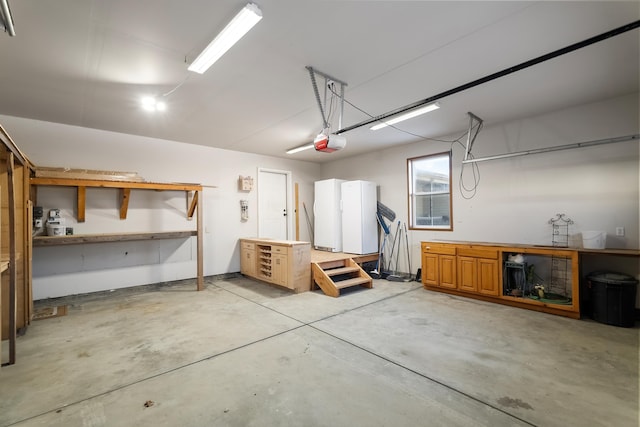 8715 W Antler Rd, Deer Park, WA 99006 - garage with a garage door opener, freestanding refrigerator, and a workshop area