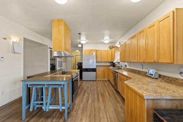 20902 S Ritchey Rd, Spokane, WA 99004 - kitchen featuring stainless steel appliances, wood finished floors, range hood, and arched walkways