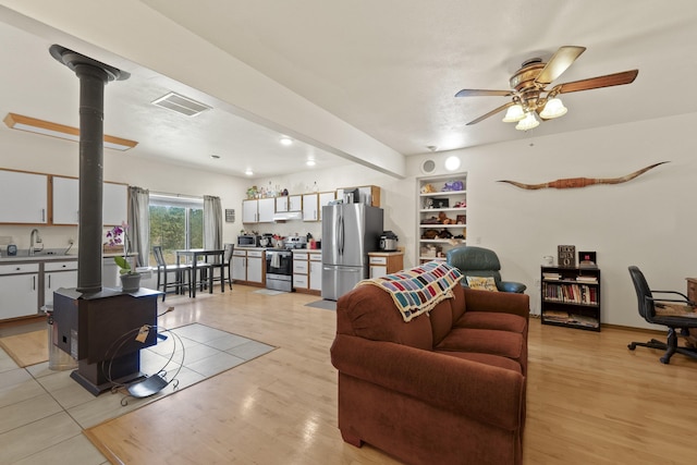 20902 S Ritchey Rd, Spokane, WA 99004 - living area featuring a wood stove, ceiling fan, and light wood finished floors