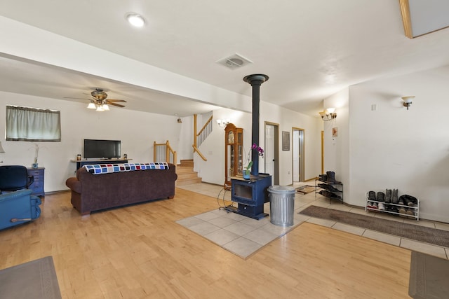 20902 S Ritchey Rd, Spokane, WA 99004 - living room with a wood stove, wood finished floors, stairs, and a ceiling fan