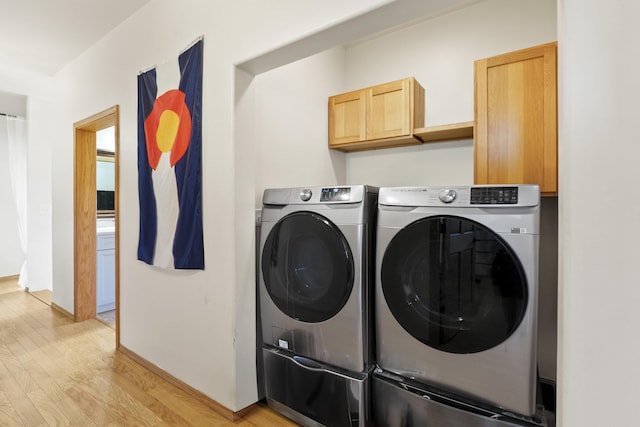 20902 S Ritchey Rd, Spokane, WA 99004 - laundry room featuring separate washer and dryer, cabinet space, and light wood-type flooring