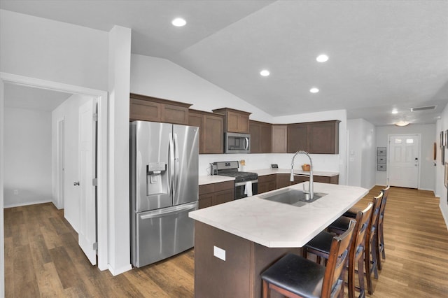 10521 W Salmonberry Rd, Cheney, WA 99004 - kitchen with stainless steel appliances, lofted ceiling, a kitchen island with sink, light countertops, and dark brown cabinets
