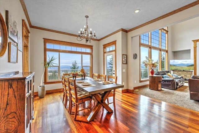 6808 S Jackson Ridge Ln, Greenacres, WA 99016 - dining space with crown molding, a textured ceiling, a chandelier, healthy amount of natural light, and wood-type flooring
