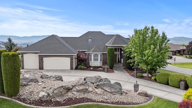 8708 E Redwood Ln, Spokane, WA 99217 - view of front of property featuring a mountain view, a garage, concrete driveway, and brick siding
