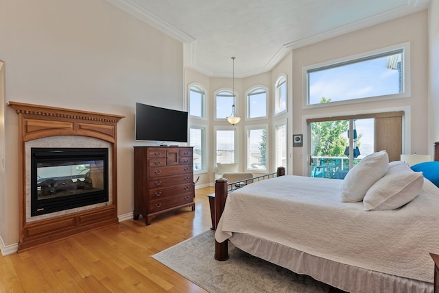 8708 E Redwood Ln, Spokane, WA 99217 - bedroom featuring ornamental molding, light wood-type flooring, access to exterior, a towering ceiling, and a multi sided fireplace