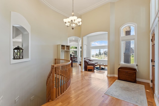 8708 E Redwood Ln, Spokane, WA 99217 - entrance foyer with arched walkways, a chandelier, a high ceiling, and light wood finished floors