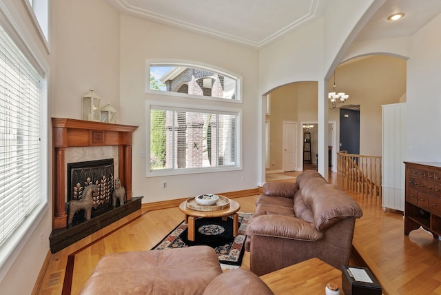 8708 E Redwood Ln, Spokane, WA 99217 - living room featuring arched walkways, a high ceiling, a chandelier, wood finished floors, and a fireplace