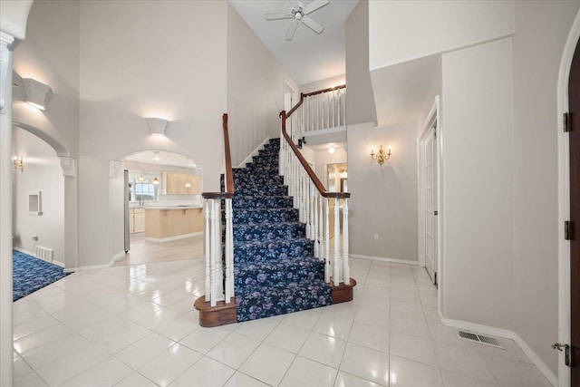 6419 W Skagit Ave, Spokane, WA 99208 - stairway featuring arched walkways, a high ceiling, tile patterned floors, and a ceiling fan