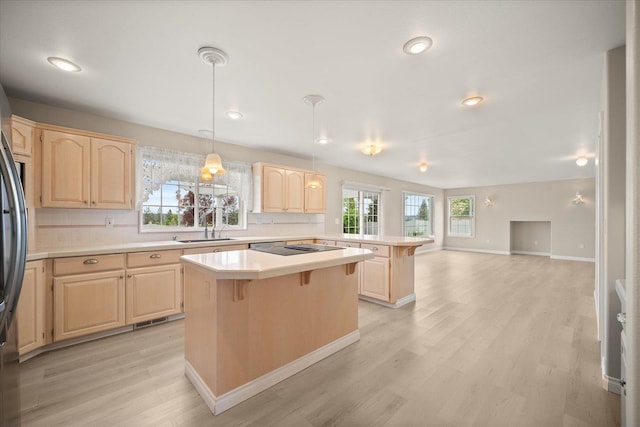 6419 W Skagit Ave, Spokane, WA 99208 - kitchen featuring light brown cabinets, light countertops, a breakfast bar, a peninsula, and backsplash