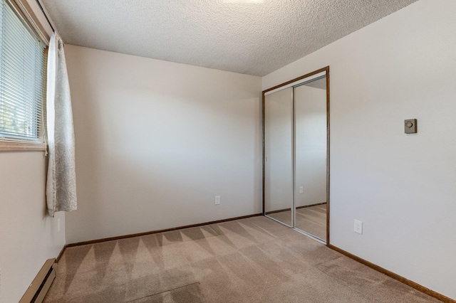 13908 E 32nd Ave, Spokane Valley, WA 99037 - unfurnished bedroom featuring baseboard heating, light carpet, a closet, and a textured ceiling