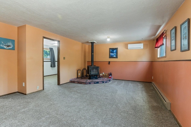 13908 E 32nd Ave, Spokane Valley, WA 99037 - unfurnished living room featuring a wood stove, baseboard heating, carpet flooring, a wall mounted AC, and a textured ceiling