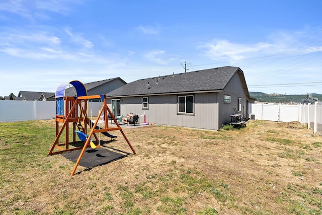 19020 E Euclid Ave, Otis Orchards, WA 99037 - rear view of property featuring a fenced backyard, a patio, roof with shingles, and a playground