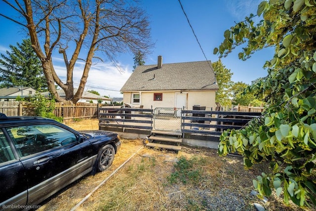 803 E Queen Ave, Spokane, WA 99207 - view of property exterior with stucco siding, a fenced backyard, a chimney, and roof with shingles