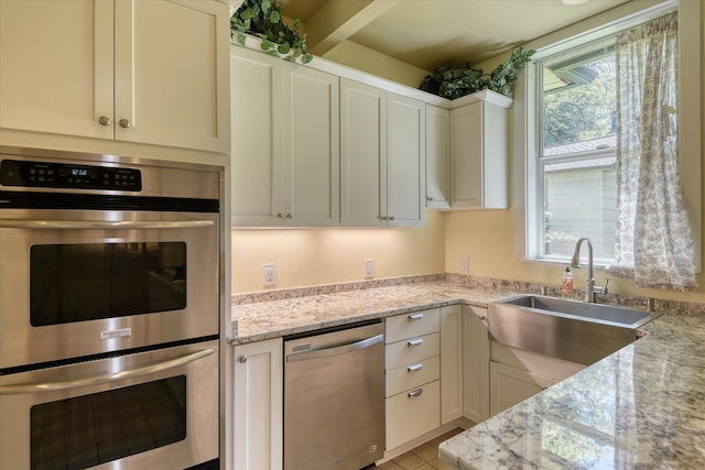 1428 E 18th Ave, Spokane, WA 99203 - kitchen featuring appliances with stainless steel finishes, white cabinets, light stone counters, and light tile patterned floors