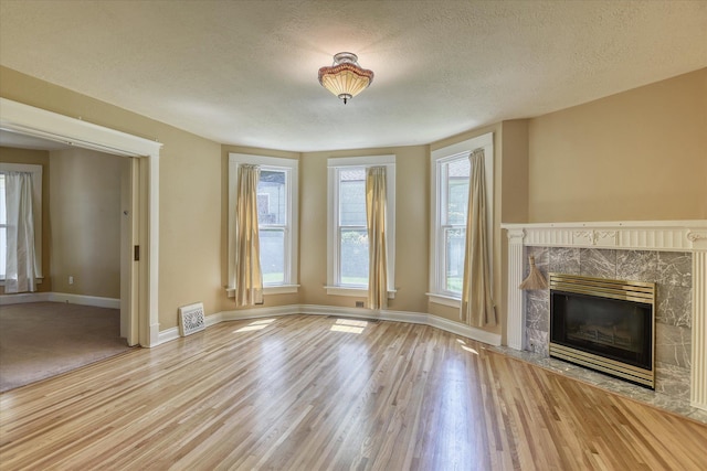 1428 E 18th Ave, Spokane, WA 99203 - unfurnished living room featuring a fireplace, wood finished floors, and a textured ceiling
