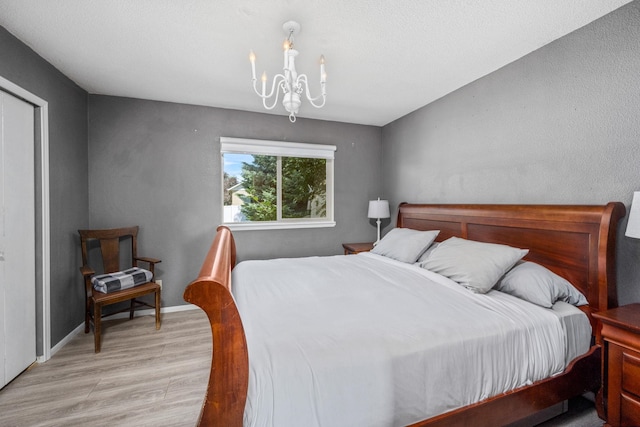 447 E Dakota Ave, Hayden, ID 83835 - bedroom with light wood-type flooring and a chandelier