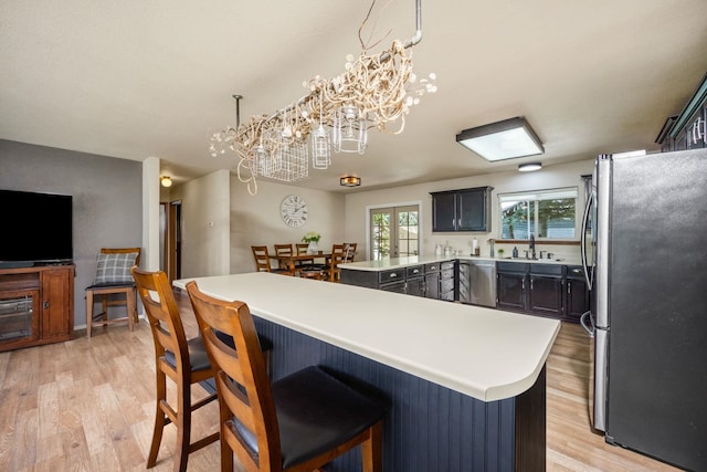 447 E Dakota Ave, Hayden, ID 83835 - kitchen with appliances with stainless steel finishes, light wood-style floors, a chandelier, light countertops, and a kitchen breakfast bar