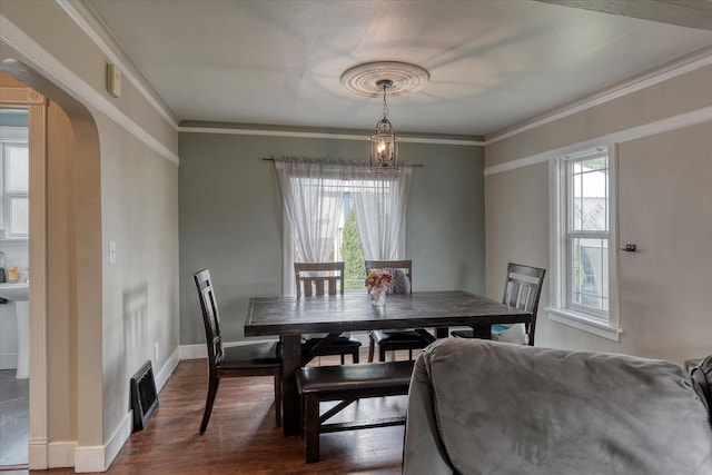 703 E Lacrosse Ave, Spokane, WA 99207 - dining area featuring dark wood-style floors, arched walkways, crown molding, and a chandelier