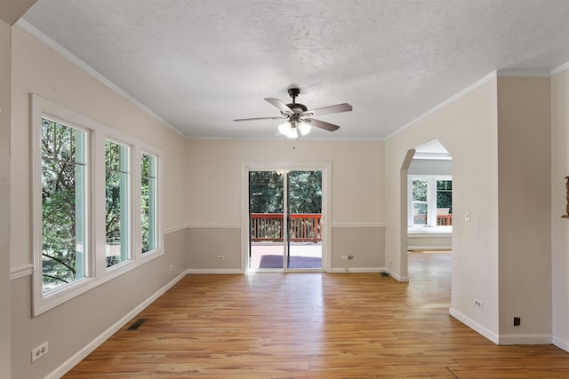 17221 N Little Spokane Dr, Colbert, WA 99005 - unfurnished room with light wood-style floors, a ceiling fan, a textured ceiling, arched walkways, and ornamental molding