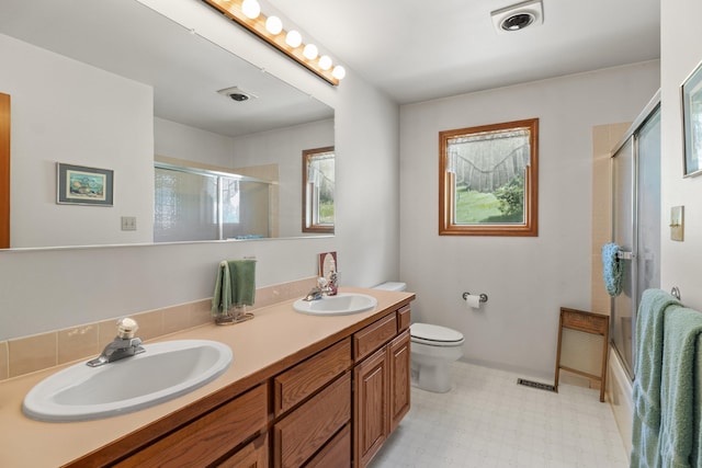 17607 E Judkins Rd, Spokane, WA 99217 - bathroom with healthy amount of natural light, double vanity, tile patterned floors, and enclosed tub / shower combo