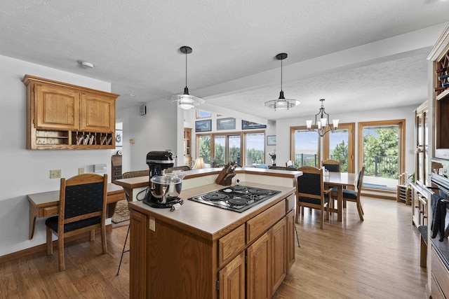 17607 E Judkins Rd, Spokane, WA 99217 - kitchen with black electric stovetop, a textured ceiling, light wood finished floors, a center island, and hanging light fixtures
