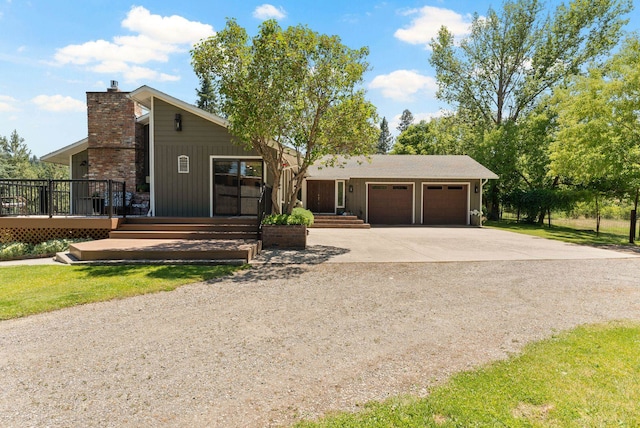 996A Basin Rd, Colville, WA 99114 - view of front of home featuring concrete driveway, a chimney, a garage, and a deck