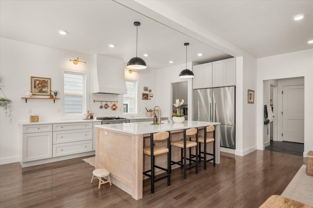 3103 W 18th Ave, Spokane, WA 99224 - kitchen with stainless steel appliances, premium range hood, light countertops, a kitchen bar, and dark wood finished floors