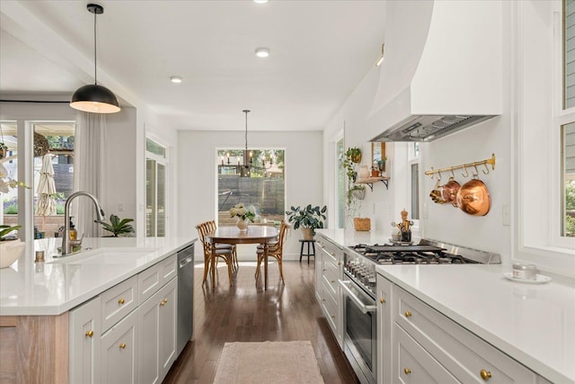 3103 W 18th Ave, Spokane, WA 99224 - kitchen with custom exhaust hood, appliances with stainless steel finishes, dark wood finished floors, light countertops, and a chandelier