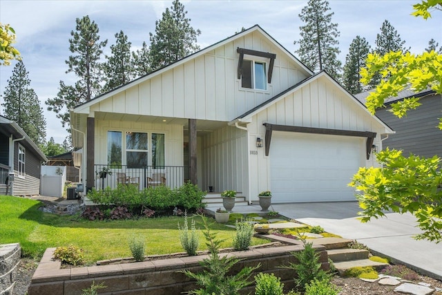 3103 W 18th Ave, Spokane, WA 99224 - view of front facade featuring covered porch, concrete driveway, board and batten siding, a front yard, and a garage