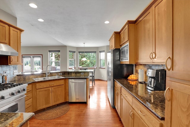 2716 S Man O War Ln, Veradale, WA 99037 - kitchen with appliances with stainless steel finishes, a peninsula, light wood finished floors, recessed lighting, and backsplash